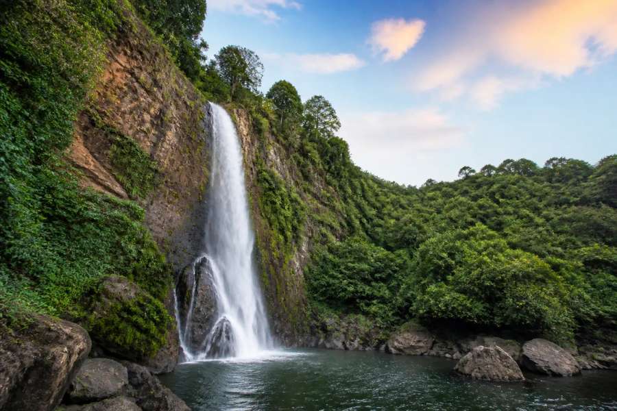 Cachoeira em meio à mata atlântica com poço de água esverdeada, paisagem vertical