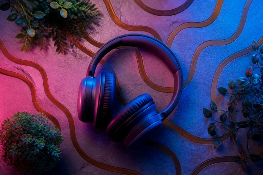 Fones de ouvido genéricos sem marca sobre superfície de concreto com plantas, produto