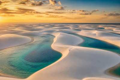 Dunas de areia branca com lagoas de água cristalina refletindo o céu, paisagem ampla